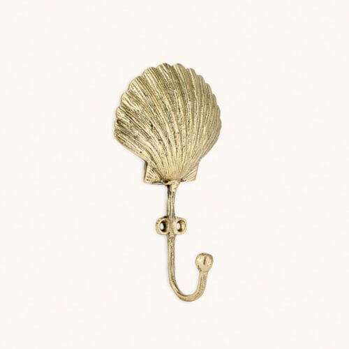 Scarlett Shell Hook from Doing Goods in recycled brass shaped like a decorative seashell.